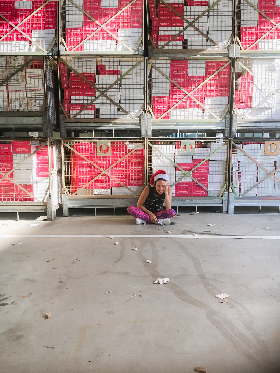 Irene sitting in front of cages stacked with Nourished Life boxes in the early warehouse days