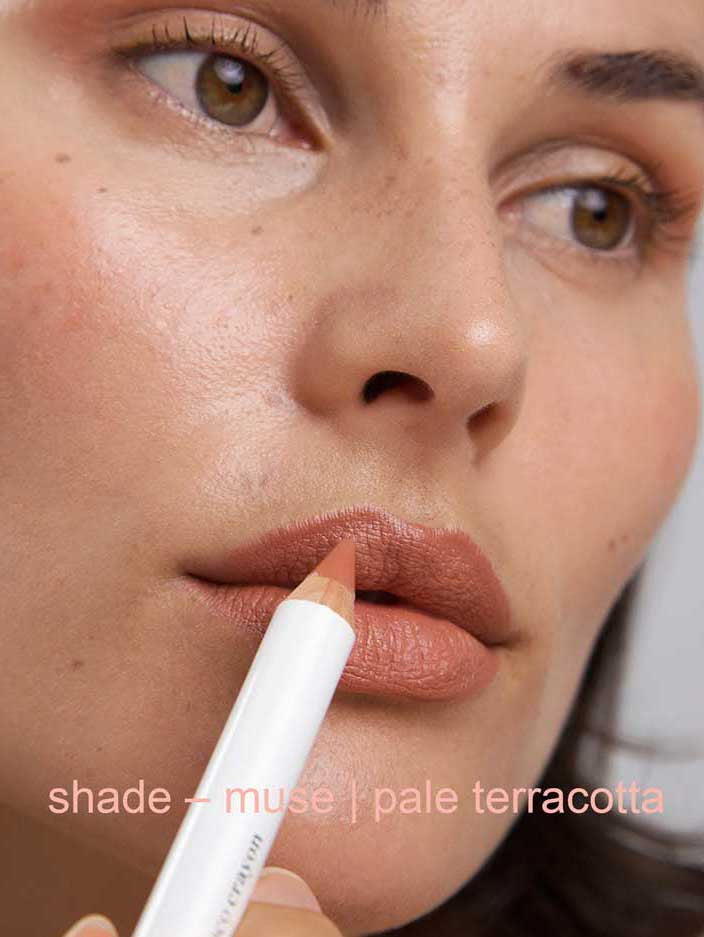 Close-up of a person holding a makeup pencil labeled 'shade - muse | pale terracotta'.