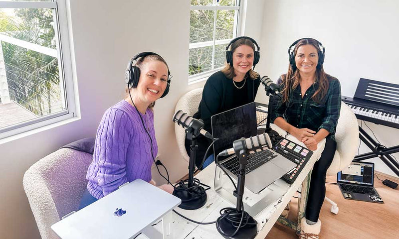 Irene Falcone, Lee Holmes and sleep psychologist Dr Amelia Scott smiling in headphones around microphones and laptops in a bright podcast studio
