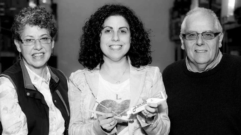 Black and white photo of Tammy Aronson from Grants of Australia with her parents, Grants founders Mike and Michelle Aronson, holding a tube of Grants toothpaste