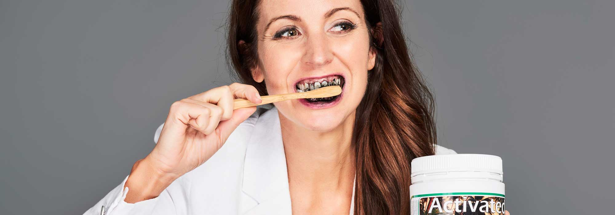 Irene Falcone brushing her teeth with activated charcoal