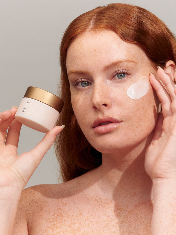 Model applying INIKA Organic Phytofuse Renew Night Cream to her face