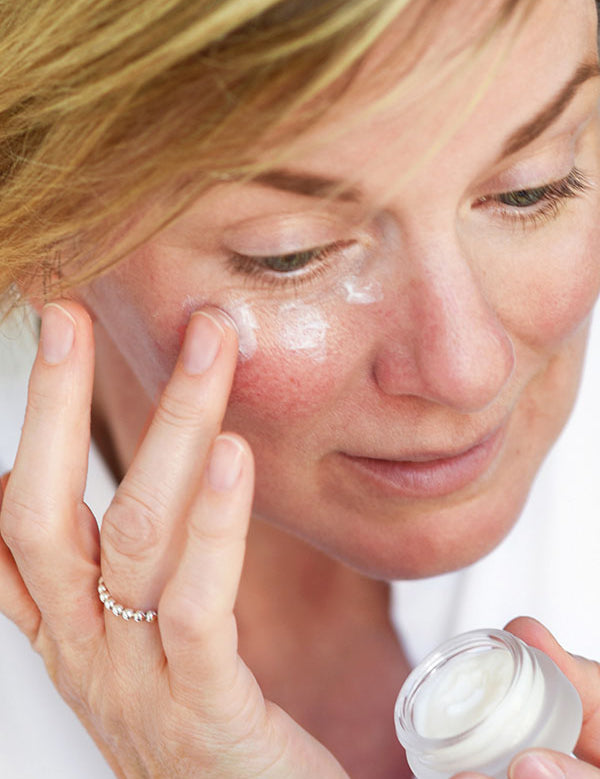 Woman applying Ere Perez Cranberry Lip and Eye Mask under her eyes with her fingertip