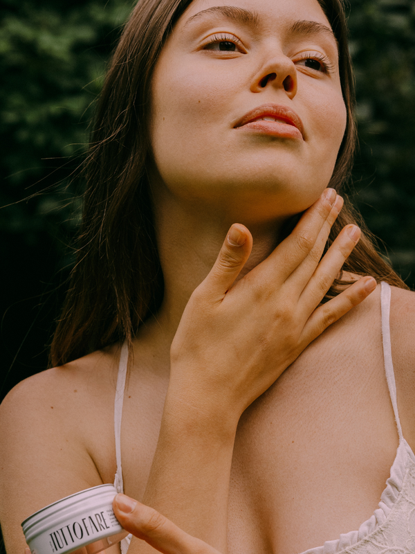 Woman applying Tuttofare Holy Grail Tallow Balm to her neck