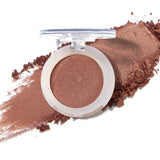 100% Pure Fruit Pigmented Eye Shadow in Cinnaban, showing an open compact beside a sweep of matching loose powder on white, with the shade name Cinnaban printed below.