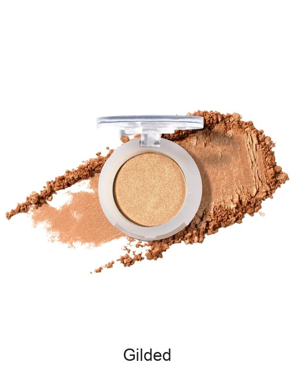 100% Pure Fruit Pigmented Eye Shadow in Gilded, showing an open compact beside a sweep of matching loose powder on white, with the shade name Gilded printed below.