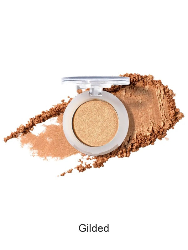 100% Pure Fruit Pigmented Eye Shadow in Gilded, showing an open compact beside a sweep of matching loose powder on white, with the shade name Gilded printed below.