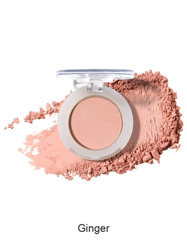 100% Pure Fruit Pigmented Eye Shadow in Ginger, showing an open compact beside a sweep of matching loose powder on white, with the shade name Ginger printed below.