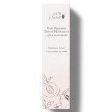 A tall white 100% Pure Tinted Moisturiser carton with black lettering, an apple saccharides label and delicate fruit and leaf drawings around the pale pink base.