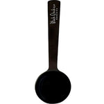 The Black Chicken Remedies Powder Scoop is a black stainless steel ladle with a flat handle and white “Black Chicken Remedies” text, displayed on a plain white background.
