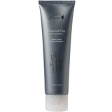 A gray tube labeled 100% Pure Charcoal Clay Cleanser, featuring white text, a bamboo illustration, and a clear cap. This 80ml cleanser by 100% Pure deeply purifies your skin with detoxifying charcoal clay.