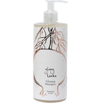 A clear pump bottle of 100% Pure Glossy Locks Glossing Shampoo, with a white label featuring a minimalist line drawing of pomegranate branches and leaves.