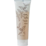 A tube of 100% Pure Glossy Locks Grow More Shampoo, a biotin-infused thickening formula, displays floral line art and brown text on white. The 8 fl oz (236 ml) upright tube has a white flip-top cap.