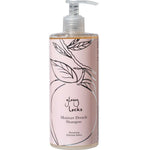A bottle of 100% Pure Glossy Locks Moisture Drench Shampoo for dry hair, with a pink label featuring a line drawing of a peach and leaves, and a pump dispenser.