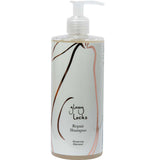 A bottle of 100% Pure Glossy Locks Repair Shampoo with a pump dispenser features the 100% Pure brand, minimalist hairline artwork, and black, brown, and pink text on a white label.