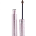 A pink tube of 100% Pure Green Tea Fibre Brow Builder 4.5g with white floral designs stands open, showing its wand applicator with vegan brown brow gel on the brush.