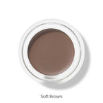 A round 100% Pure Long Last Brows 4.5g container with soft brown cream is shown from above, labeled Soft Brown. This vegan formula by 100% Pure also works as a natural brow gel for an effortless, long-lasting look.