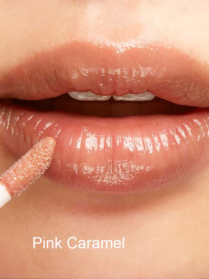 Close-up of lips with 100% Pure Lip Gloss in a light pinkish nude shade, enriched with vitamin E. The shade “Pink Caramel” is labeled in white text at the bottom.
