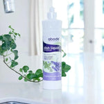 Abode Dishwashing Liquid Lavender and Mint bottle on a kitchen bench beside the sink with trailing ivy