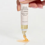 Hand squeezing The Jojoba Company Ultimate Plumping Lip Treatment from the tube