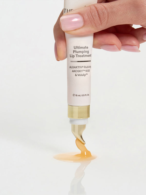 Hand squeezing The Jojoba Company Ultimate Plumping Lip Treatment from the tube