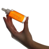 Hand holding a bottle of The Jojoba Company Jojoba Boost Super Antioxidant