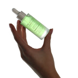Hand holding a bottle of The Jojoba Company Jojoba Boost Skin Renewal