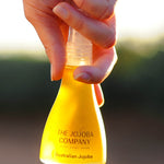 Hands holding the 85ml bottle of The Jojoba Company Australian Jojoba