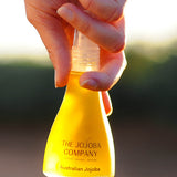 Hands holding the 85ml bottle of The Jojoba Company Australian Jojoba