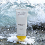The Jojoba Company Australian Jojoba Aqua Gel tube on the beach with waves behind