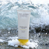 The Jojoba Company Australian Jojoba Aqua Gel tube on the beach with waves behind