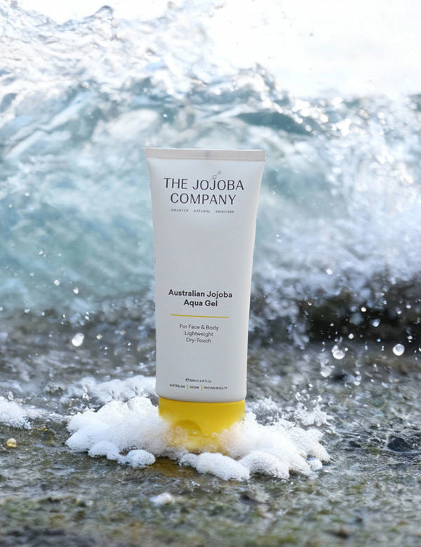 The Jojoba Company Australian Jojoba Aqua Gel tube on the beach with waves behind