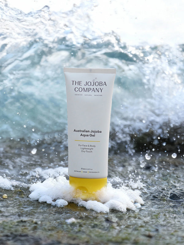 The Jojoba Company Australian Jojoba Aqua Gel tube on the beach with waves behind