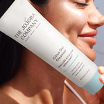 Woman holding a tube of The Jojoba Company Citrus Gel Cleanser