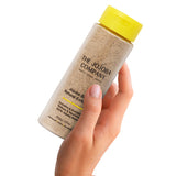 Hand holding The Jojoba Company Jojoba Bean Natural Exfoliant bottle