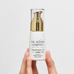 Hand holding a bottle of The Jojoba Company Pigmentation Oil