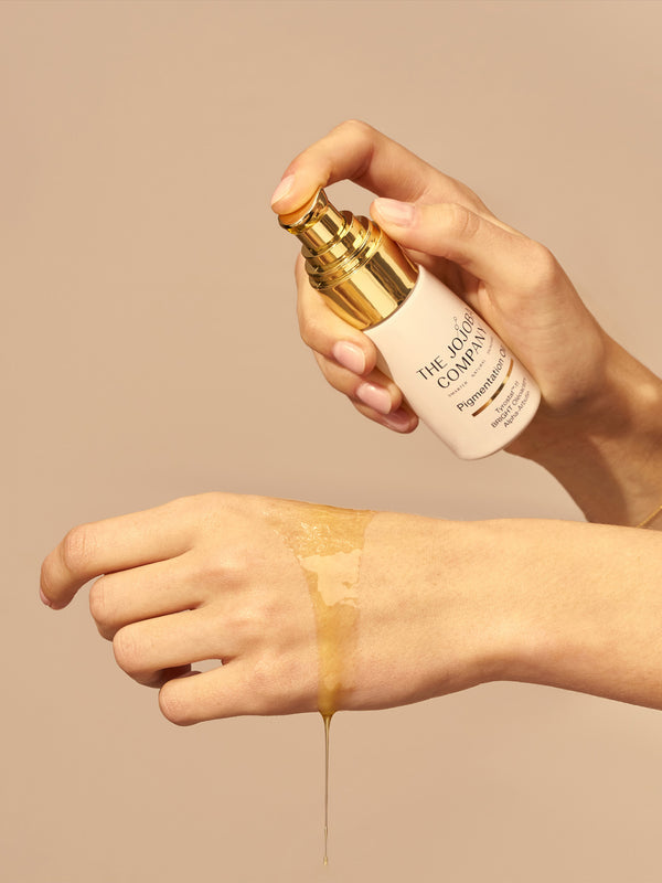 Applying The Jojoba Company Pigmentation Oil to the wrist