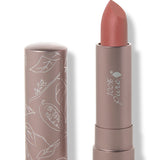 100% Pure Cassia matte lipstick with a slanted warm terracotta rose tip extended from a taupe tube; its matching cap stands beside it with white botanical line drawings.