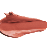 A thick smear of warm terracotta rose Cassia matte lipstick on white, with a smooth centre and raised, creamy ridges around the edges.