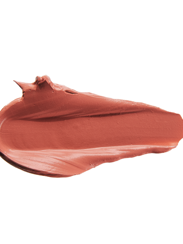 A thick smear of warm terracotta rose Cassia matte lipstick on white, with a smooth centre and raised, creamy ridges around the edges.