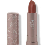100% Pure Cacti matte lipstick with a slanted rust brown tip extended from a taupe tube; its matching cap stands beside it with white botanical line drawings.