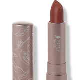 100% Pure Cacti matte lipstick with a slanted rust brown tip extended from a taupe tube; its matching cap stands beside it with white botanical line drawings.
