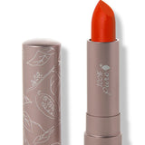 100% Pure Cactus Bloom matte lipstick with a slanted vivid orange red tip extended from a taupe tube; its matching cap stands beside it with white botanical line drawings.