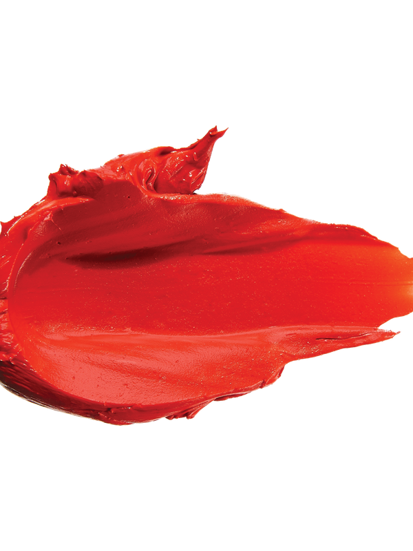 A thick smear of vivid orange red Cactus Bloom matte lipstick on white, with a smooth centre and raised, creamy ridges around the edges.