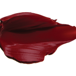 A thick smear of dark burgundy red Desert Rose matte lipstick on white, with a smooth centre and raised, creamy ridges around the edges.