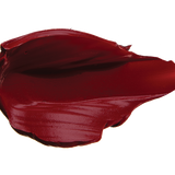 A thick smear of dark burgundy red Desert Rose matte lipstick on white, with a smooth centre and raised, creamy ridges around the edges.