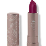 100% Pure Hyacinthus matte lipstick with a slanted deep plum purple tip extended from a taupe tube; its matching cap stands beside it with white botanical line drawings.