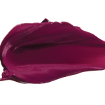A thick smear of deep plum purple Hyacinthus matte lipstick on white, with a smooth centre and raised, creamy ridges around the edges.