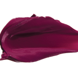A thick smear of deep plum purple Hyacinthus matte lipstick on white, with a smooth centre and raised, creamy ridges around the edges.