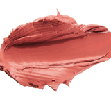A thick smear of muted coral pink Mirage matte lipstick on white, with a smooth centre and raised, creamy ridges around the edges.